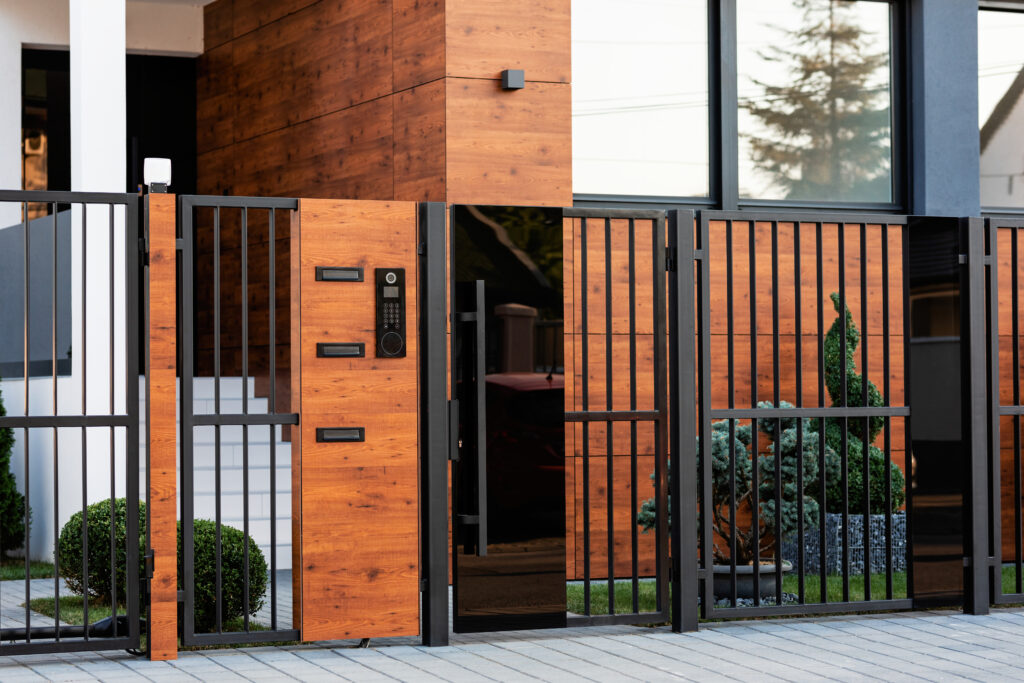 Modern wooden and black metal entrance gate and fence in front of a stylish house, shown in Prestons, New South Wales, Australia.